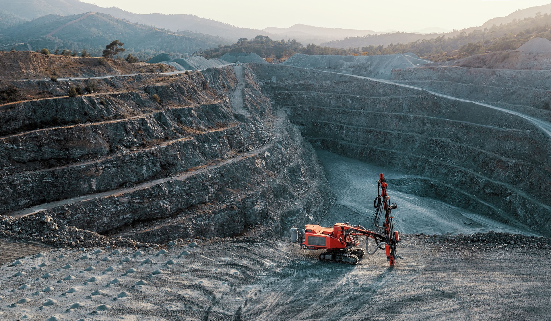 Red stone crusher on a terrace of gravel quarry